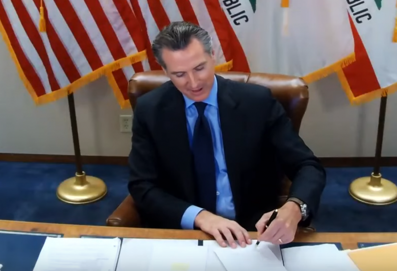 Gov Newsom signing bill sitting at desk